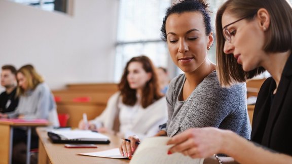 Multikulturelle Gruppe von Studierenden sitzen in einem Auditorium.
