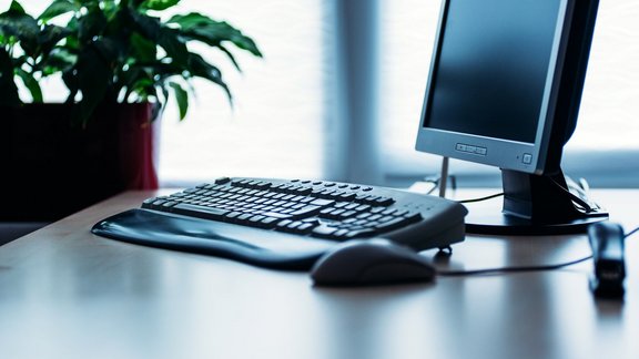 Schreibtisch mit Monitor, Maus und Tastatur